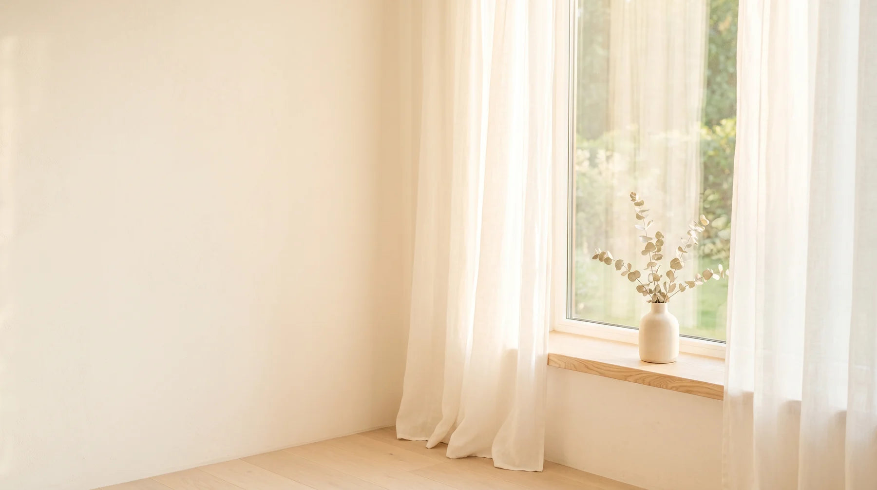 Soft golden dawn light through a sheer linen curtain on a pale windowsill